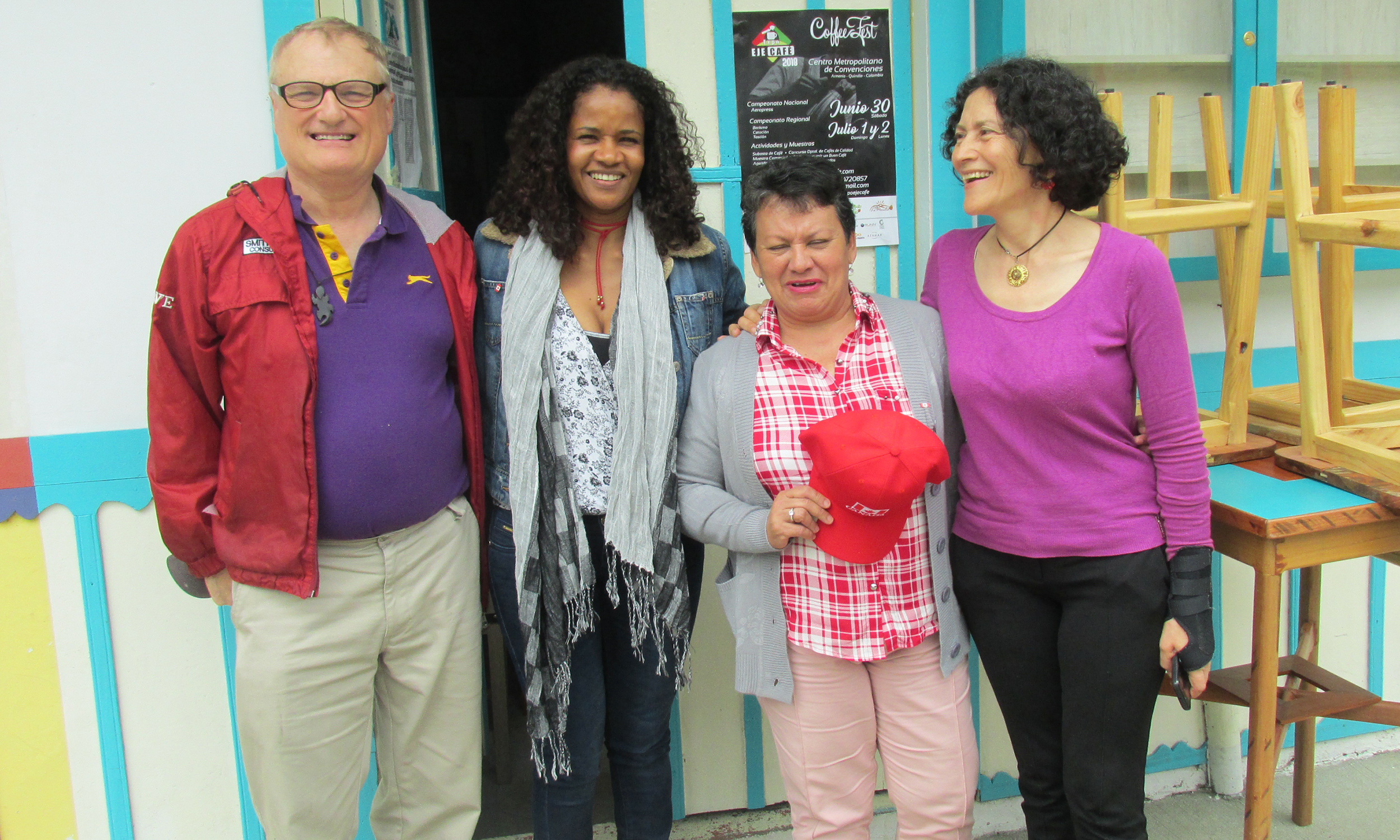 Four people in Colombia smile and put arms around each other