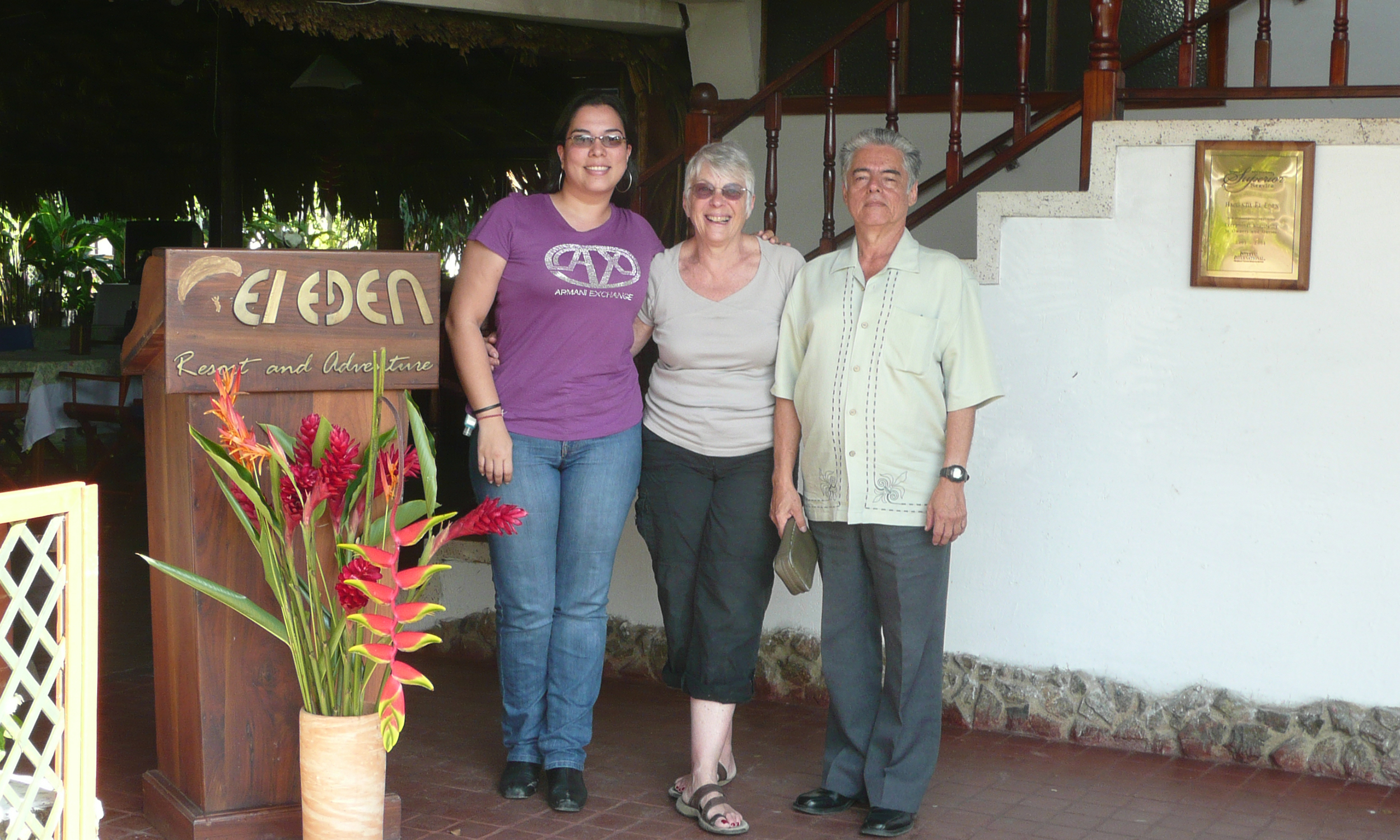 Three people by white staircase outside a hotel in Colombia