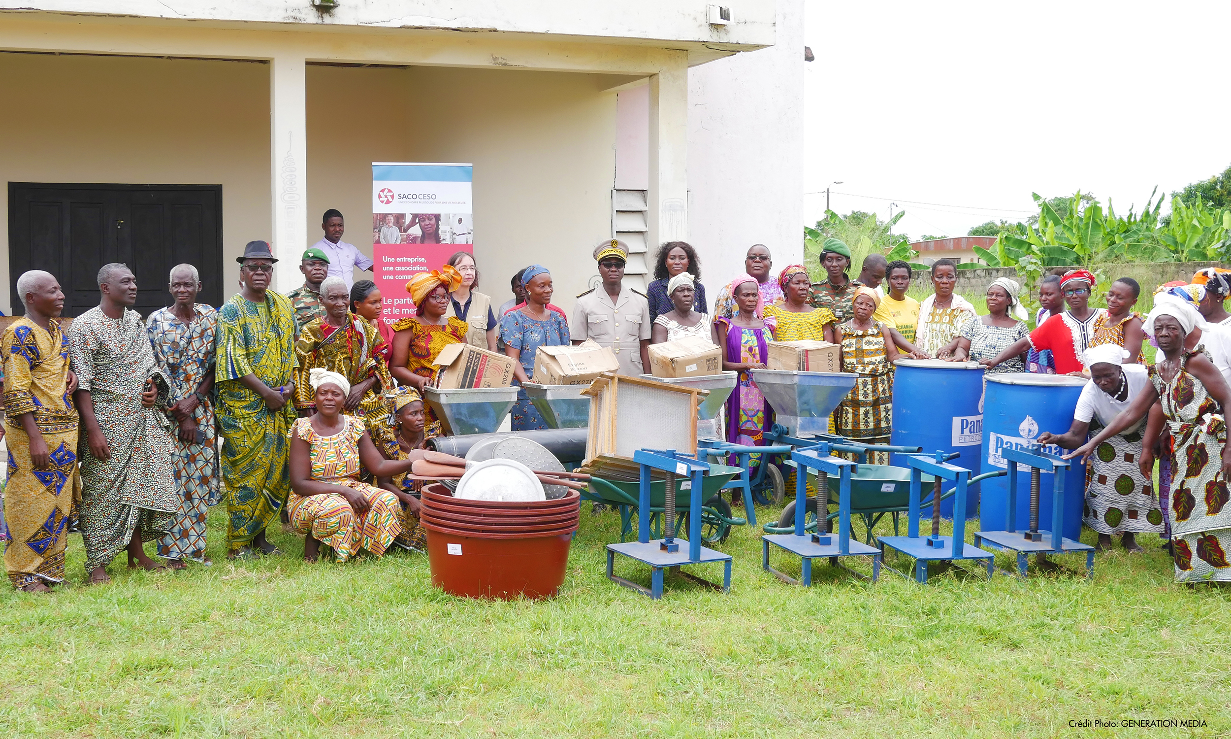 A group shot of members of a rural community in Ivory Coast receiving farming equipment