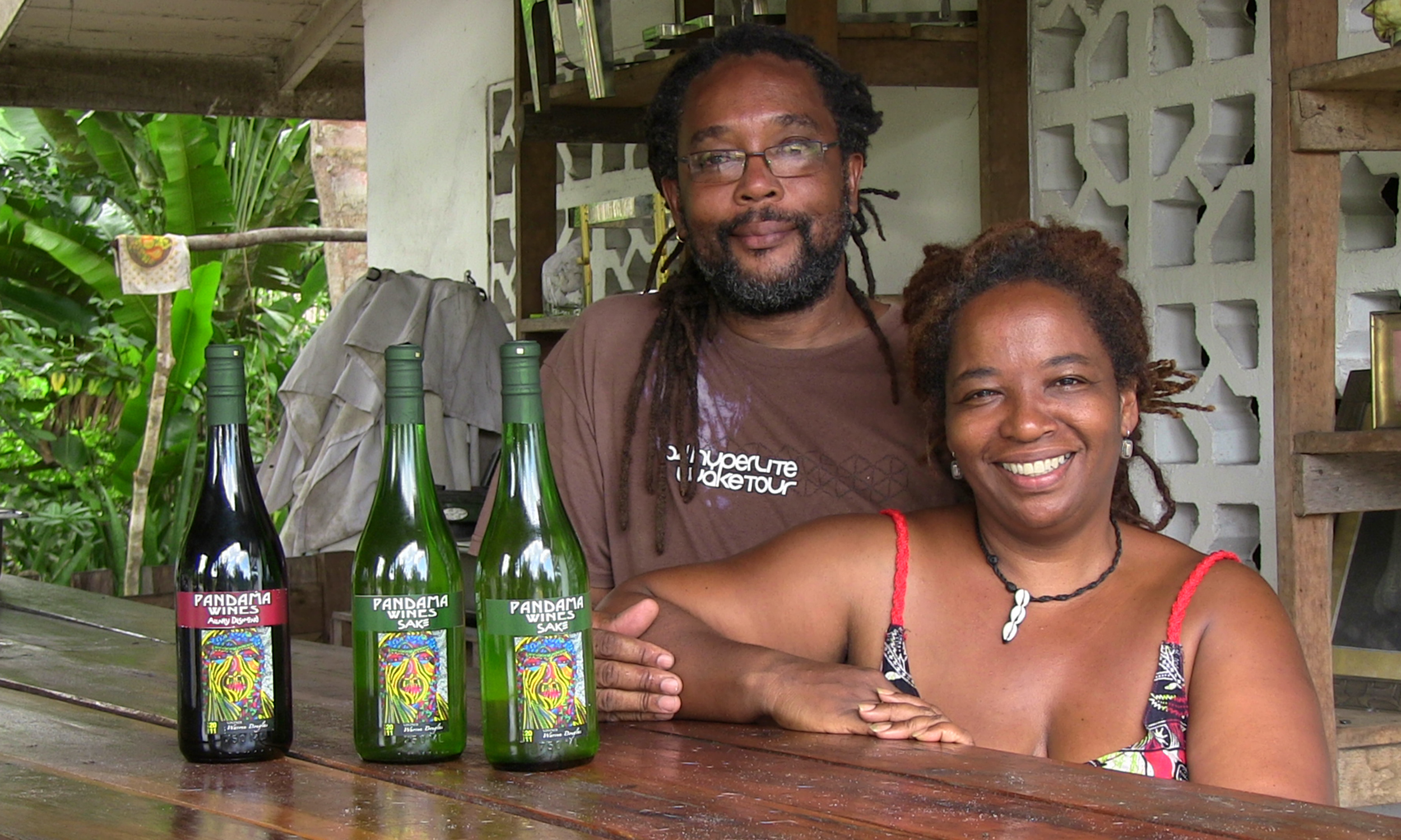 A man and a woman stand at a bar with three bottles