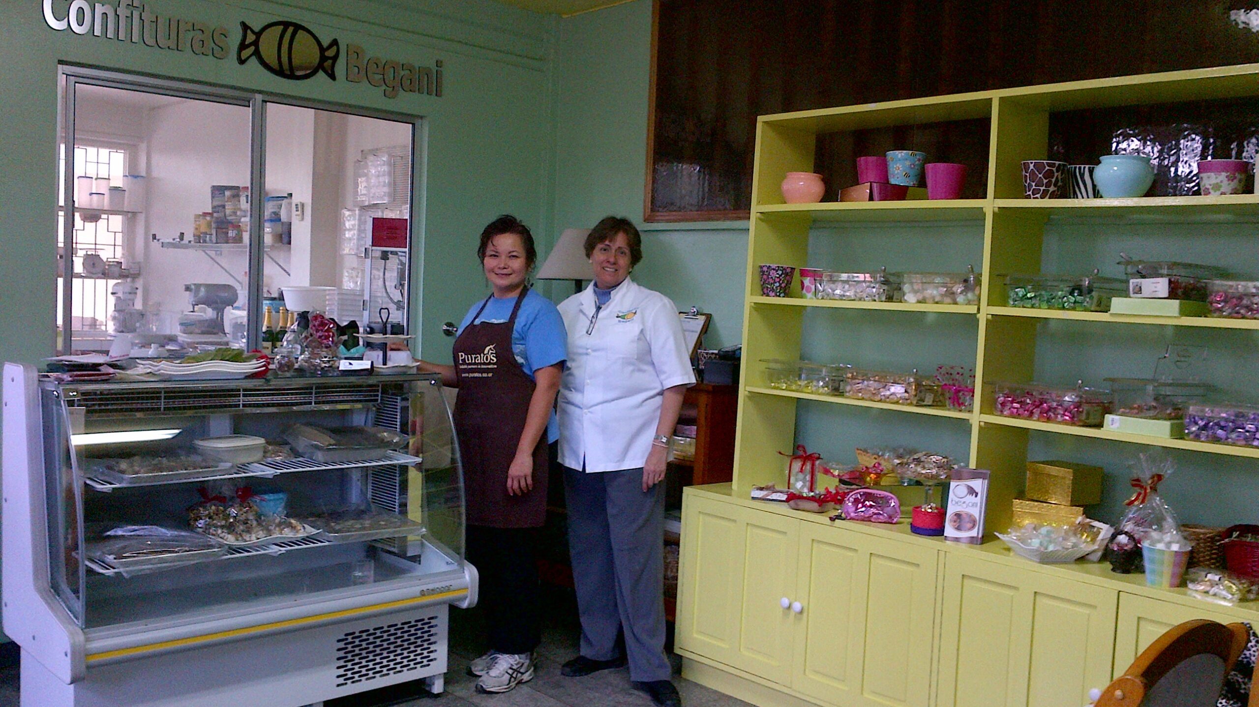 Two women stand in a confectionary shop